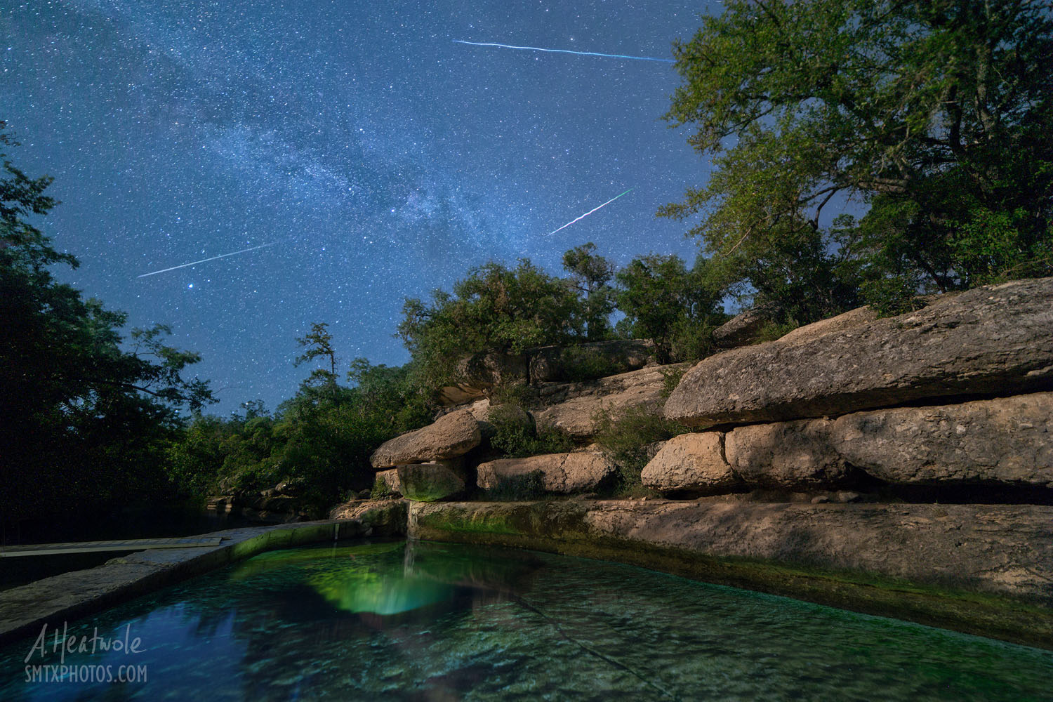 Jacob's Well in Wimberley, TX at night with shooting stars.